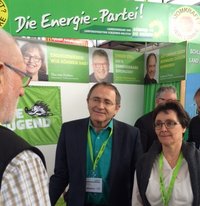 Bernd Voß mit Finanzministerin Monika Heinold im Gespräch mit einem Besucher der Messe New Energy in Husum